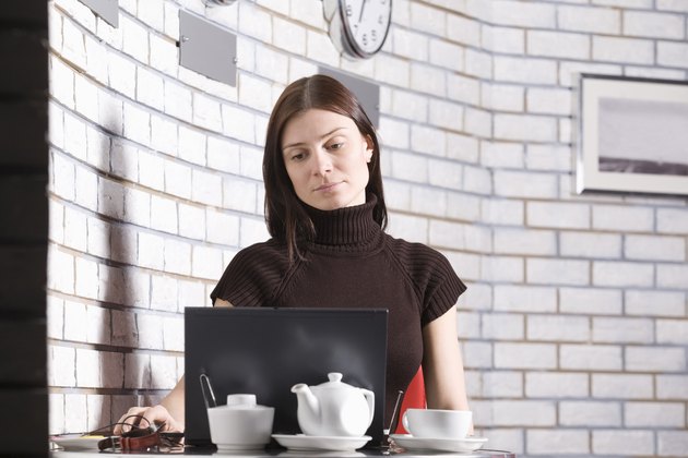 Young woman using laptop in cafe