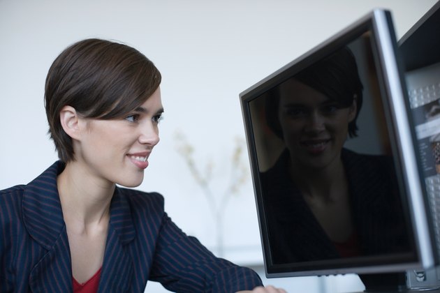 Businesswoman staring at reflection on computer screen