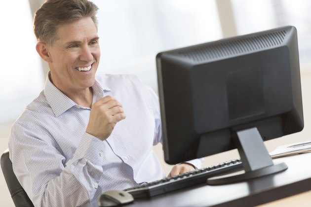 Happy Businessman Looking At Computer Monitor