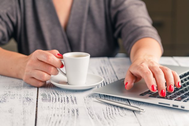 Woman drinking coffee and using digital tablet in the morning