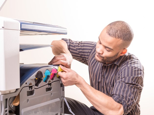 african man fixing photo copier