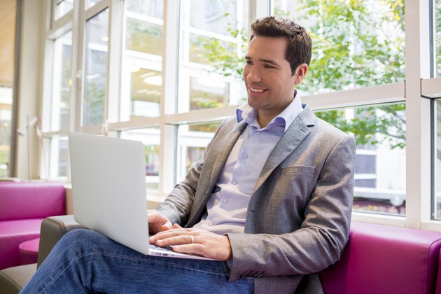 Happy smiling young Businessman working with Laptop on sofa