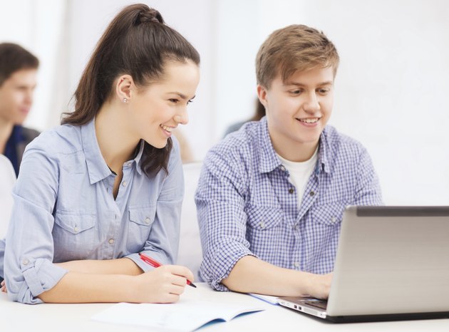 students with laptop and notebooks at school