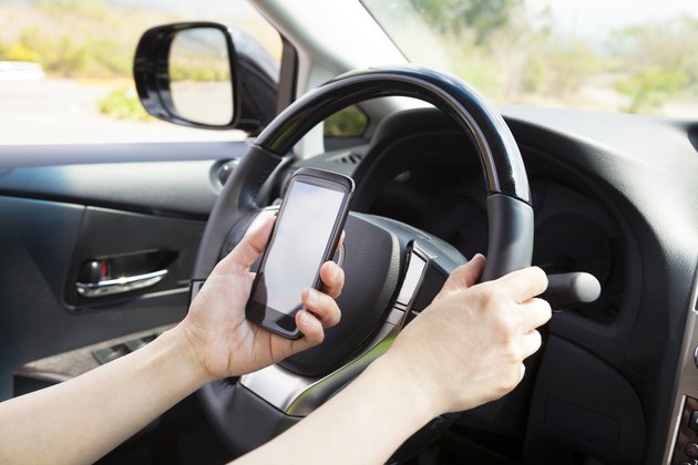 smart phone in hand while driving