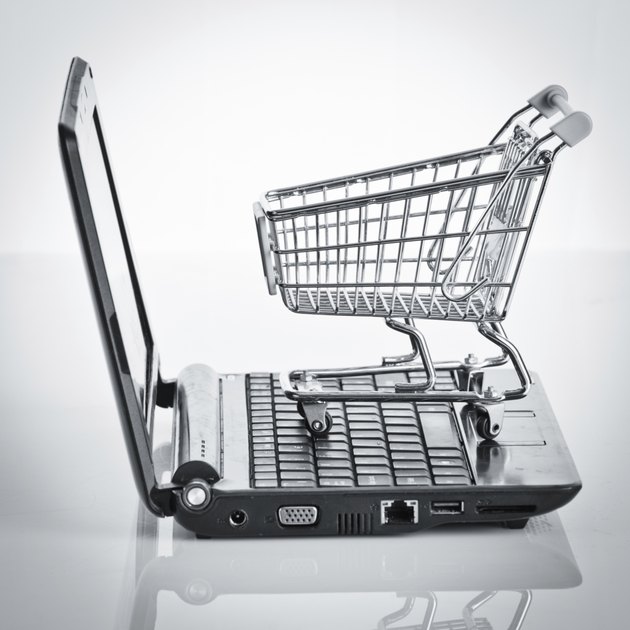 Online shopping. Shopping cart with notebook on the white. shopp