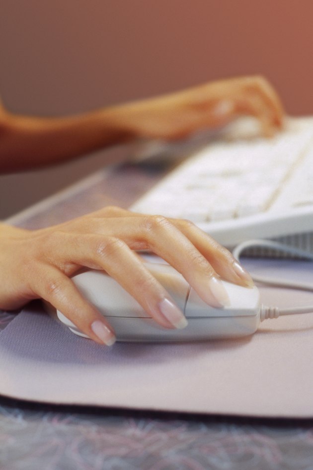 Female hands using computer mouse and keyboard