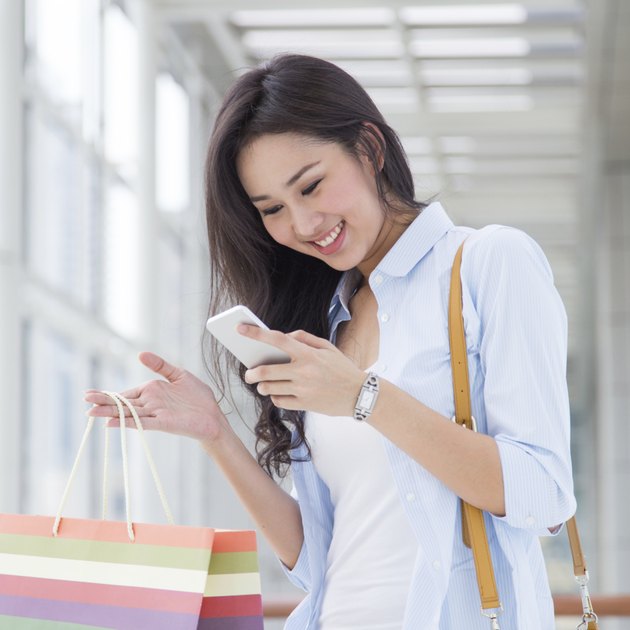 Happy young Asian woman shopping.