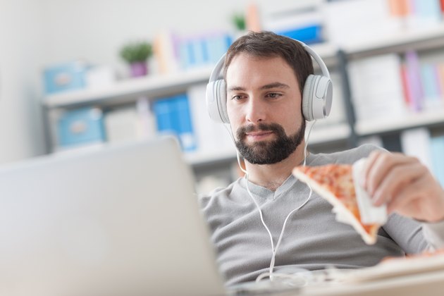 Man surfing the net and having a snack