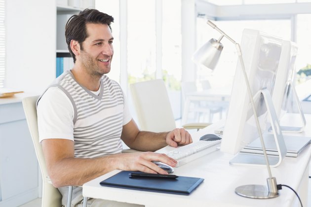 Smiling casual young man using computer