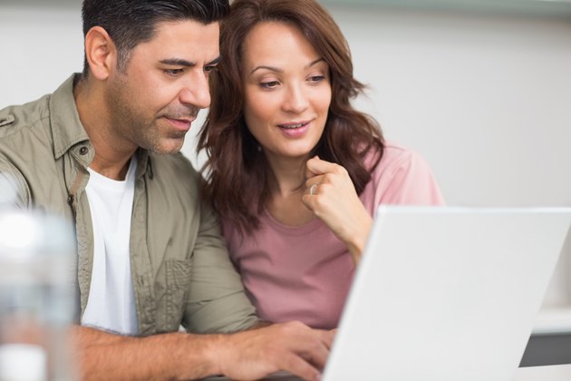 Couple using laptop in the kitchen
