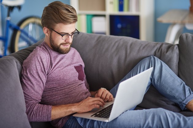 Stylish man using laptop at home