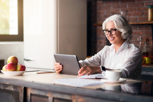 Elegant elderly woman using laptop