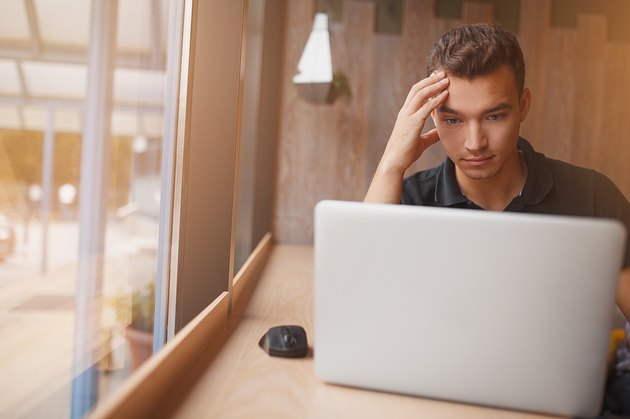 handsome hipster modern man working inside cafe at window