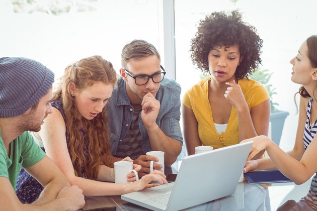 Group of students around a laptop