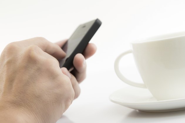 Businessman Using Cell Phone with coffee cup