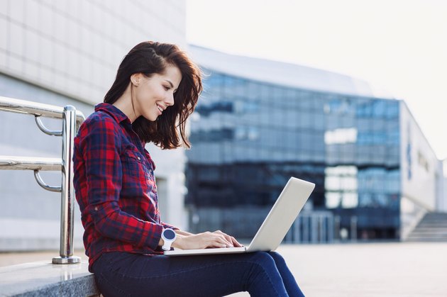 Student girl using laptop outdoors