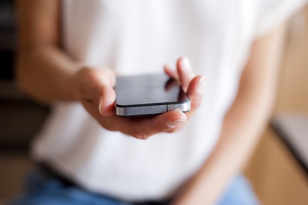 Young woman handing smartphone