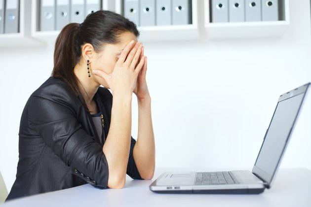 Tired young business woman with laptop