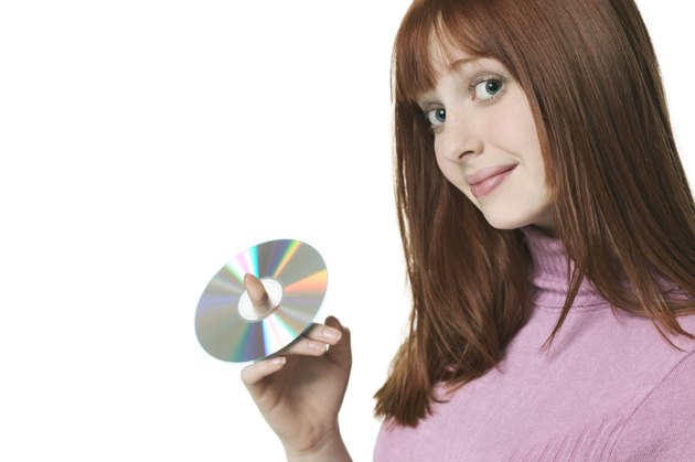 close up shot of a teenage female as she holds up a cd on her finger