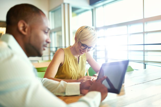 Two creative millenial small business owners working on social media