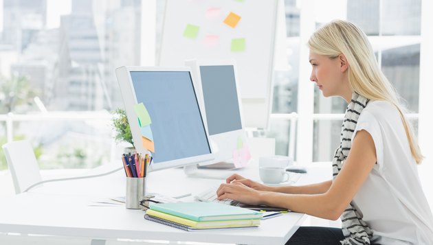 Casual young woman using computer in office