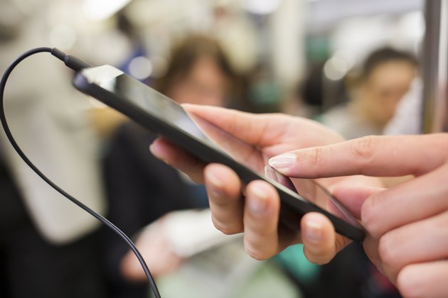 Woman listens to music with her cell phone in subway