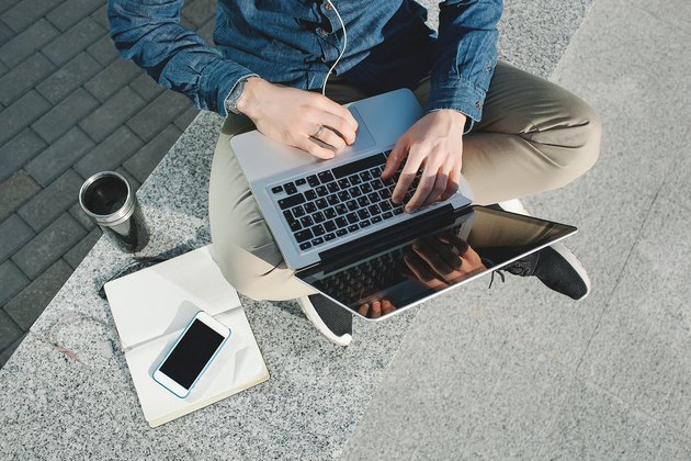 Smartphone, coffee tablet and laptop in man hands outdoors