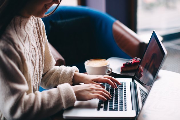 Smiling hipster girl using laptop