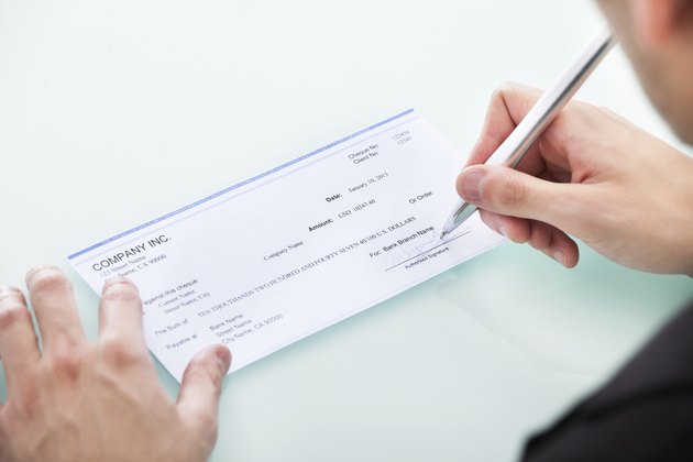 Businessman Signing On Cheque