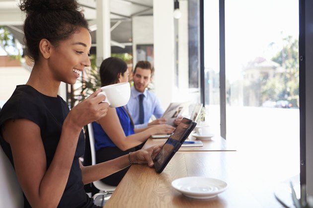 Businesswoman Using Digital Tablet In Coffee Shop