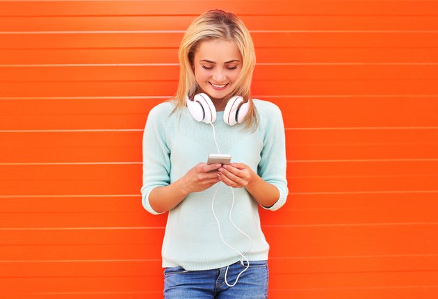 Fashion, technology and people concept - pretty smiling girl usi