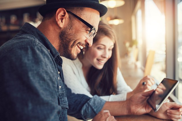 Young couple using a digital tablet at a coffee shop