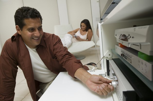 Man Adjusting Dial on Stereo