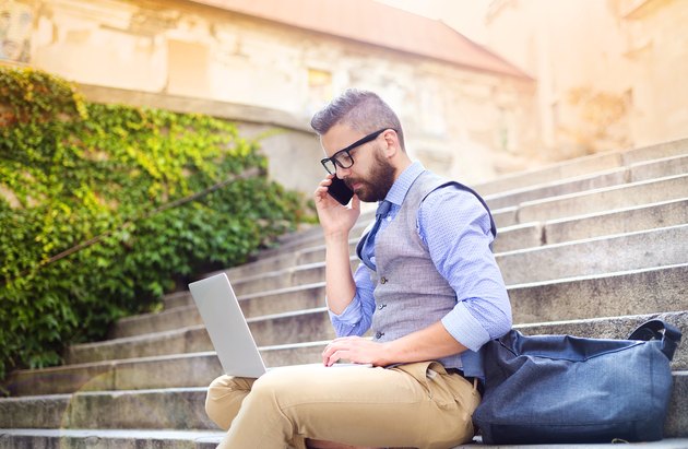 Hipster businessman with phone and laptop