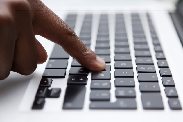 black finger typing on computer keyboard