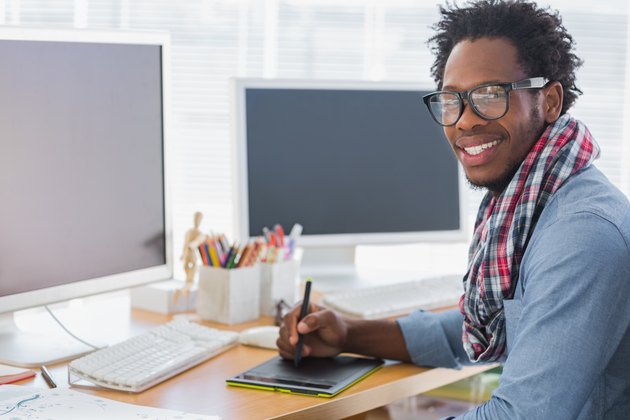 Smiling graphic designer using a graphics tablet