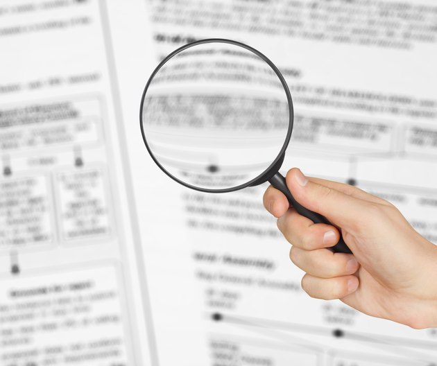 Magnifying glass in hand and business text