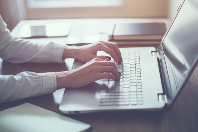 Woman working in home office hand on keyboard close up