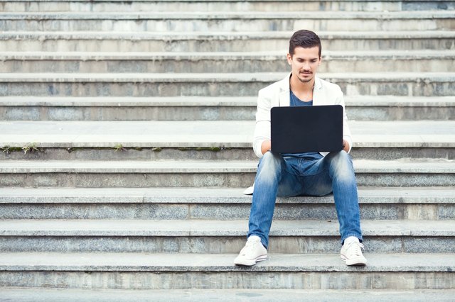 Man Sitting on the Stairs Using Laptop