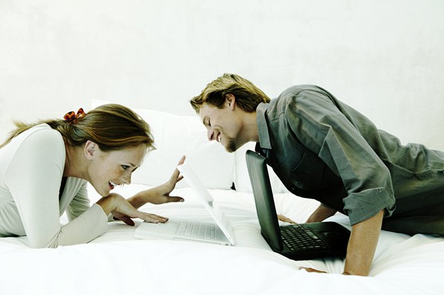 Playful couple with laptops