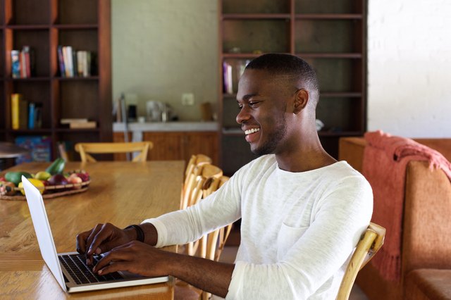 Young african man working on laptop indoors