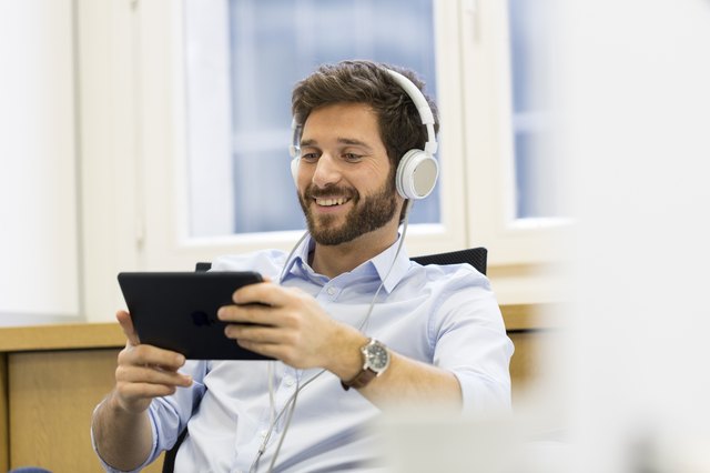 Man in office with tablet pc and headphones