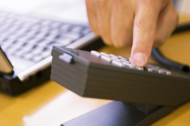 Businessman dialling number on telephone