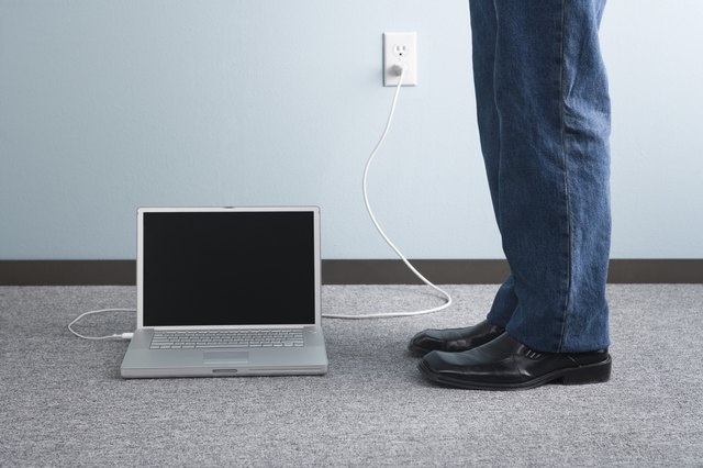 Adult standing beside laptop computer