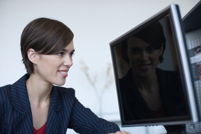 Businesswoman staring at reflection on computer screen