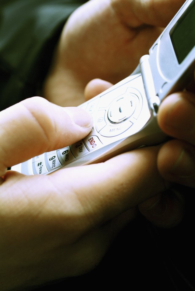 Extreme close-up of person using keypad on cell phone, part of