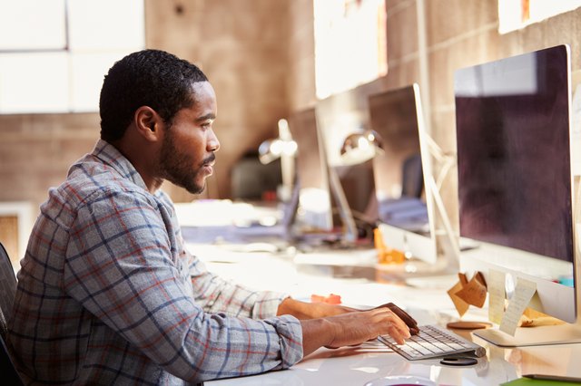 Male Designer Working At Desk In Modern Office