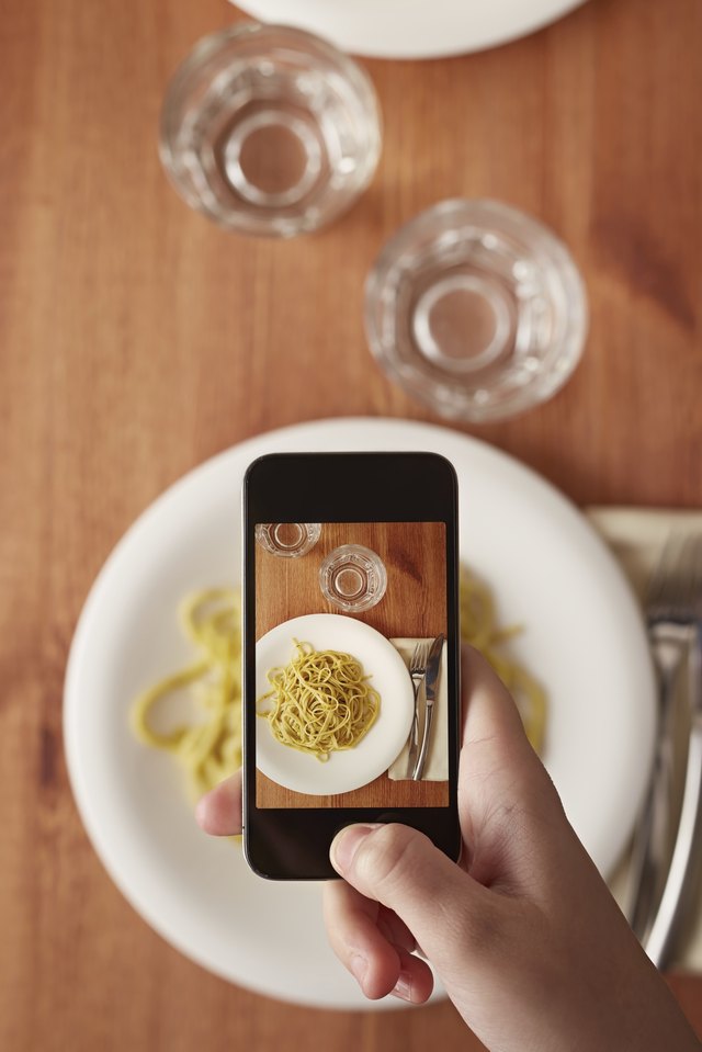Hands taking photo of lunch with smartphone