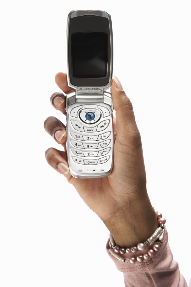 Young woman holding cell phone, close-up of hand