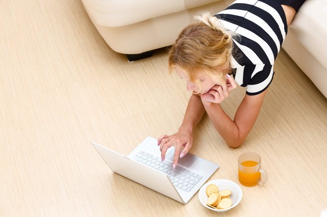 Girl looks in the laptop from the couch